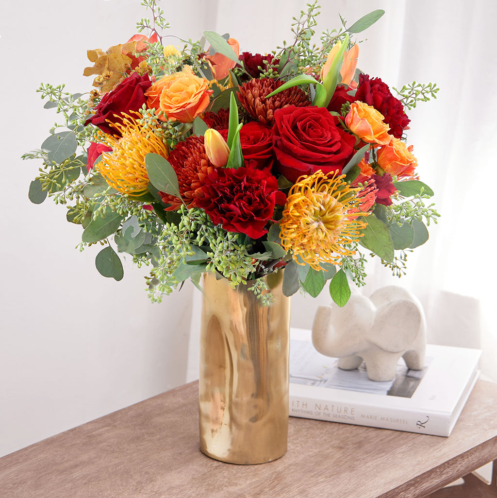 Bouquet of Freedom Roses, Tulips, Orange Spray Roses, Spider Mums, and Pincushion Protea with Seeded Eucalyptus greeneries.