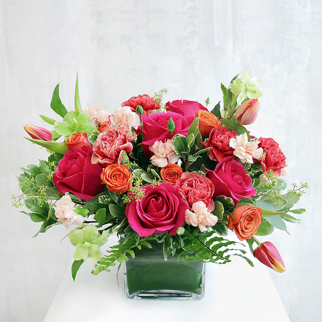 Bouquet of Queenberry Roses, Piet Carnations, Double Tulips, Hellebores, and Green Hydrangea with Pittosporums and Dusty Miller greeneries.