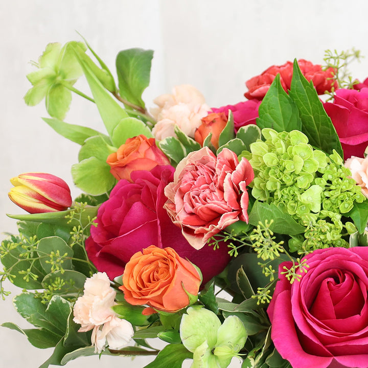 Bouquet of Queenberry Roses, Piet Carnations, Double Tulips, Hellebores, and Green Hydrangea with Pittosporums and Dusty Miller greeneries.